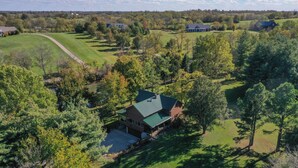 A large house with a green roof surrounded by trees and a grassy area. - Scenic Stillwater Retreat in rural KY Horse Country, WiFi/AC, Fishing/Canoeing (Georgetown)