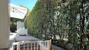 A patio area with outdoor seating, a stone wall, and a metal gate. - Welcome to Villa Lodo - The Perfect Retreat for Couples   (Sicilia)