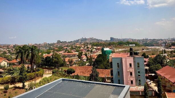 A residential area with houses, a water tower, and a large building with a green roof. - Sawe Homes 4&5 (Kampala)
