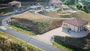 A residential area with houses, a swimming pool, and a road. - Gite TT Confort Proche Millau / Roquefort VUE Panoramique Piscine Chauffee (SAINT-VICTOR-ET-MELVIEU)