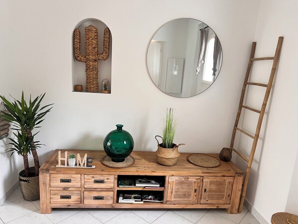A wooden console table with a green vase, a potted plant, and a mirror above it. - Villa Idéalement Située à Moins de 300 m de la Plage (La Croix-Valmer)