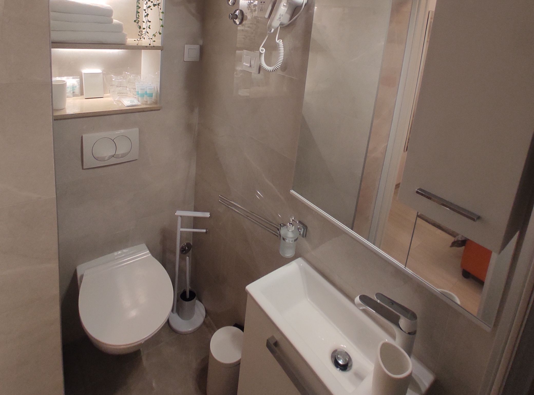 Ein kleines Badezimmer mit Toilette, Waschbecken und Dusche.