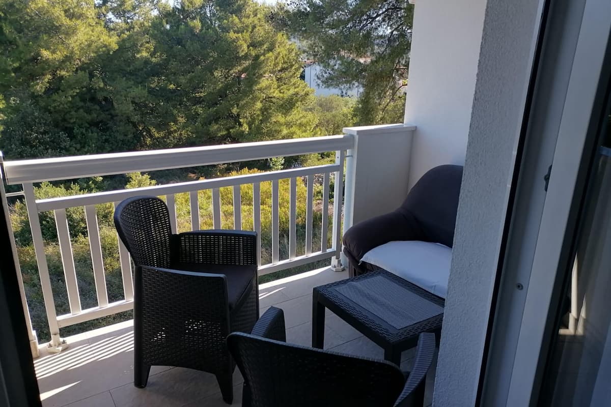 Un balcon avec une chaise, une petite table et un canapé.