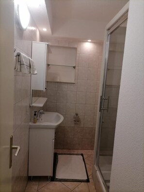 A small bathroom with a sink, mirror, and towel rack. - Apartments Libertas (Rogoznica)