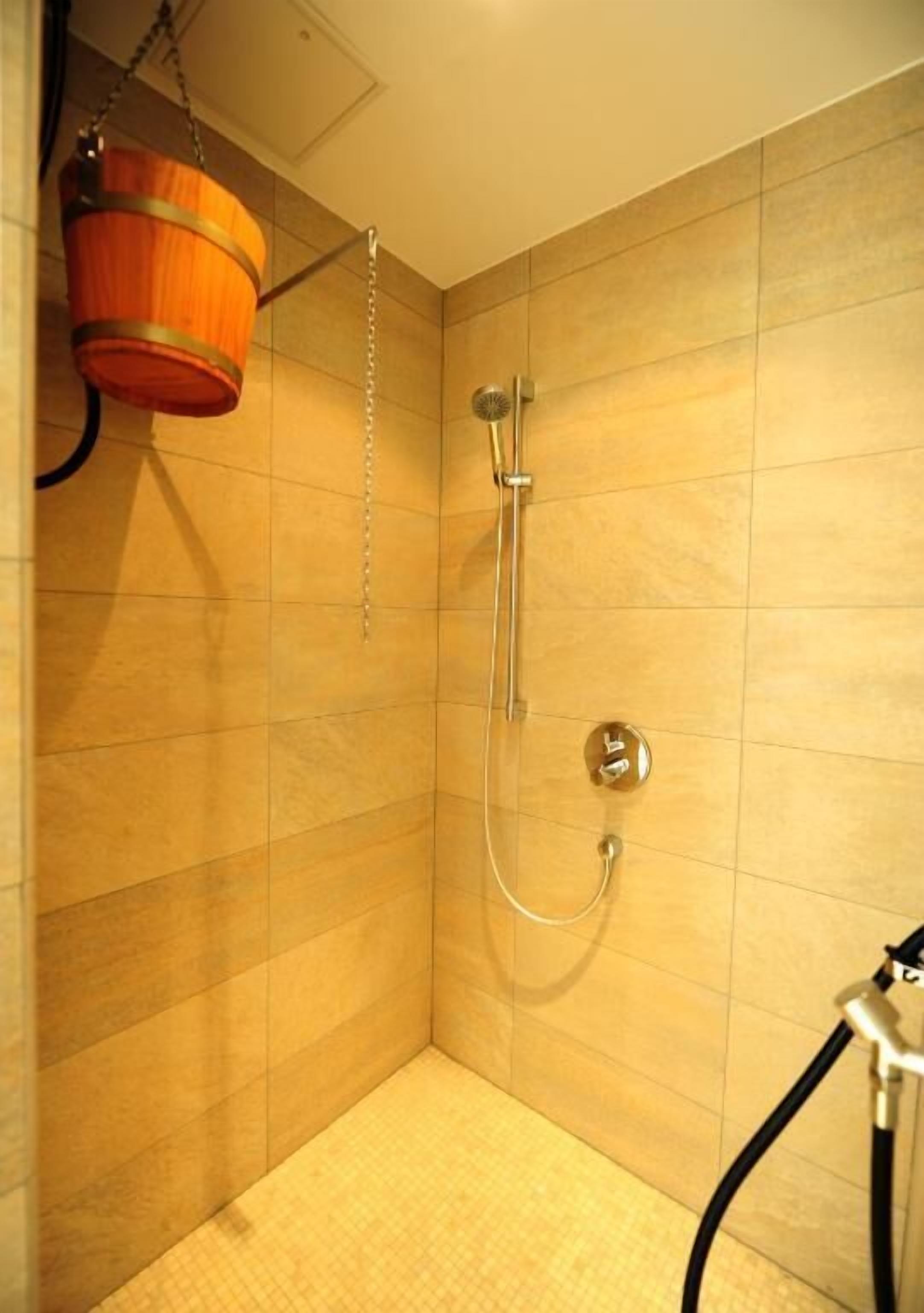 A shower area with tiled walls and a showerhead.