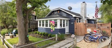 A house with a covered porch, a satellite dish, and a flag.