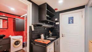 Cocina compacta con lavadora, lavaplatos y una pequeña encimera.