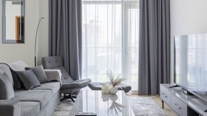 A modern living room with a grey sofa, a coffee table, and a TV.
