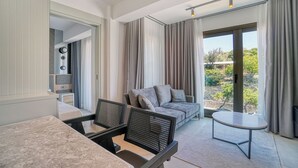 A modern living room with a sofa, two armchairs, a small round table, and a balcony with curtains. - Ayayorgi Homes & Suites (Cesme)