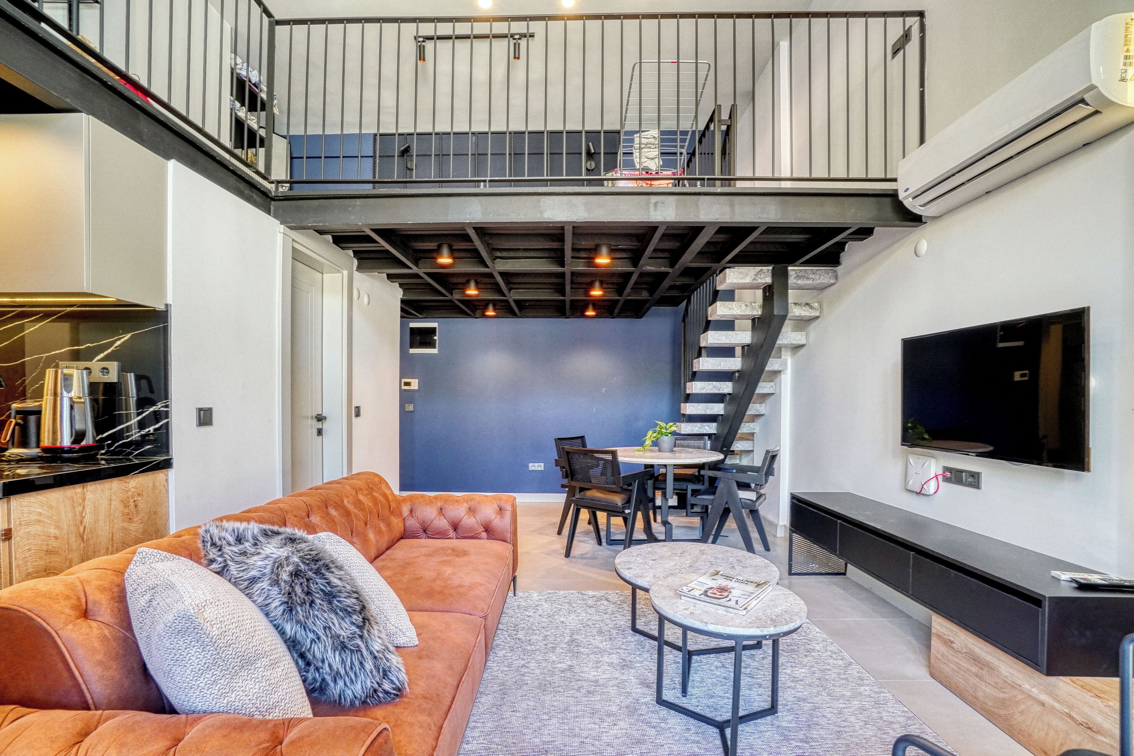 A modern living room with a sofa, coffee table, and a dining area with chairs and a table.