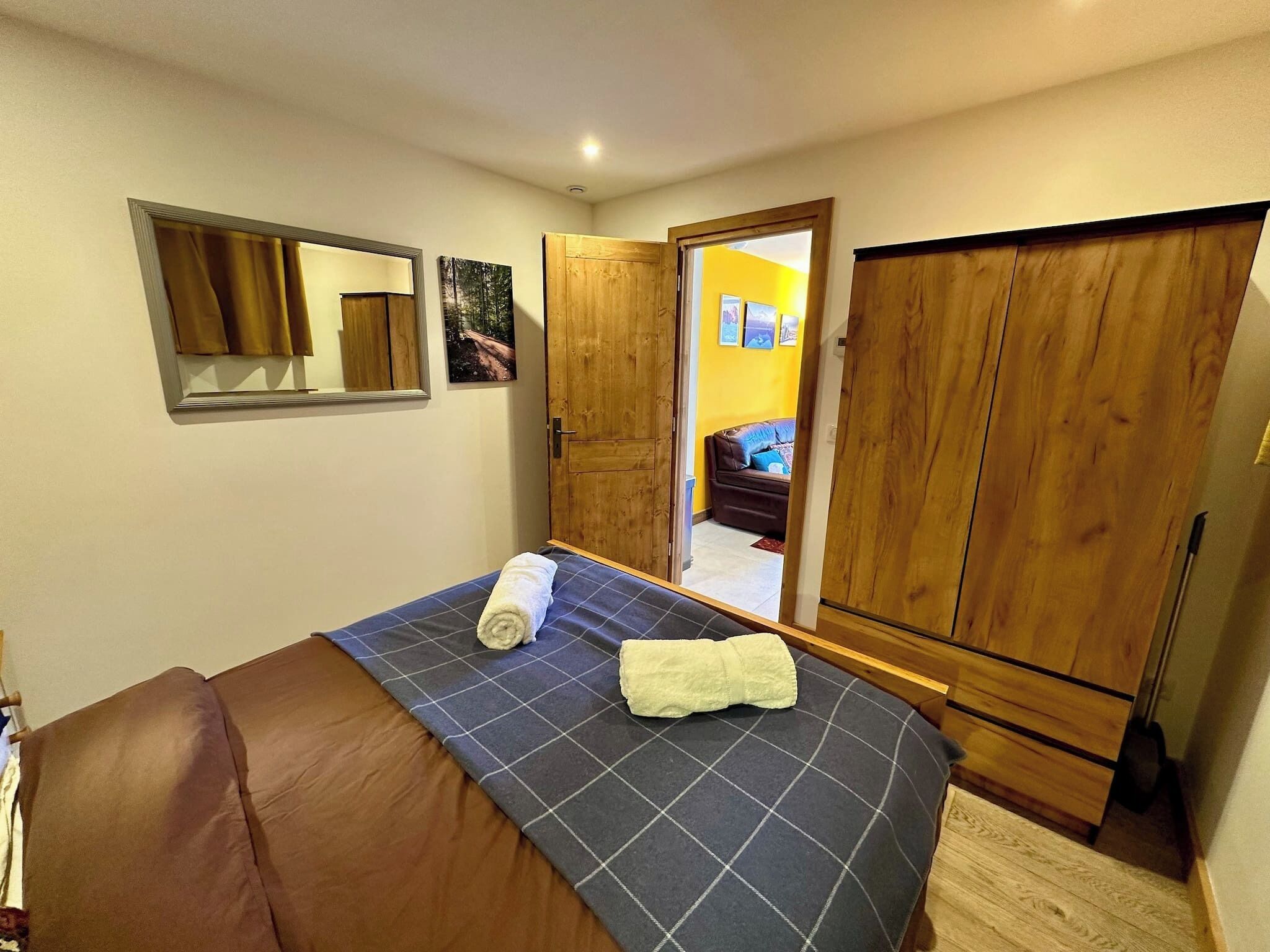 Een slaapkamer met een bed, een kledingkast en een spiegel.