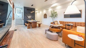 Ein großzügiger Wohnbereich mit Treppe, Esstisch, Sofa und Deckenventilator.