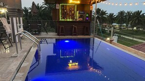 A swimming pool with a bar area, a neon sign, and outdoor seating. - Cozy 2-bedroom hotel with AC and WiFi in delightful Tela (Tela)