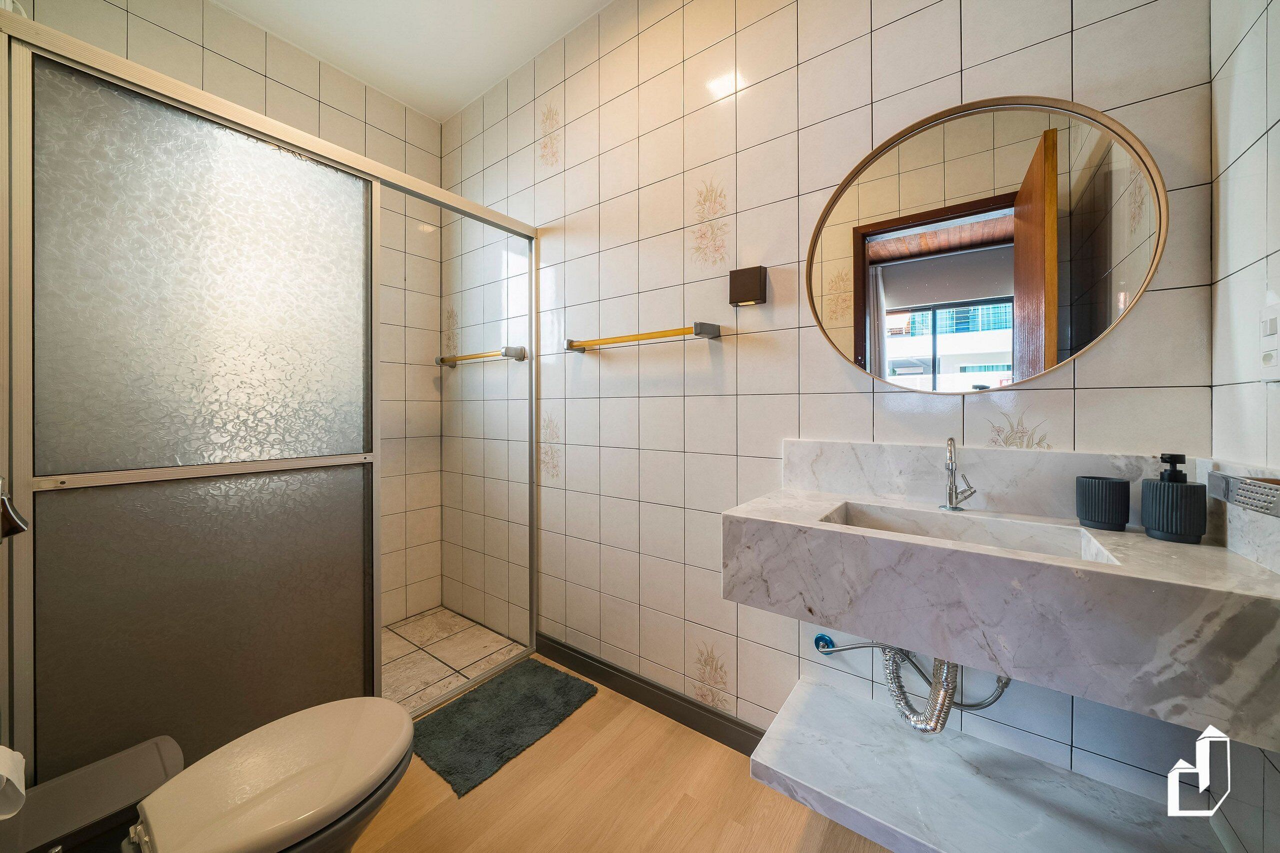 Un baño moderno con ducha, inodoro y tocador.