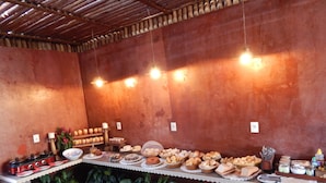 Una cocina rústica con una encimera larga que exhibe varios productos horneados y una estufa a gas.