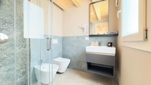 Une salle de bain moderne avec une douche à parois de verre, un lavabo blanc et des toilettes.