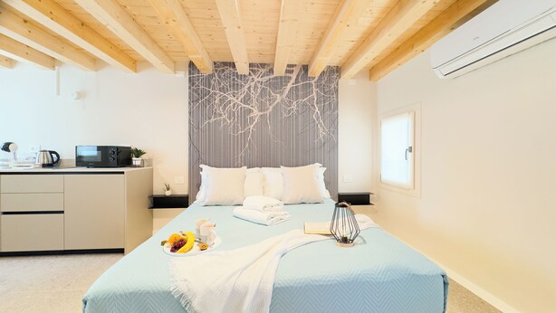Une chambre comprenant un lit, une table de chevet et un coin cuisine.