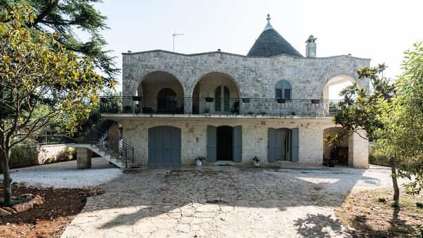 A stone building with arched doorways and a balcony. - Casa Alina by Wonderful Italy (Fasano)