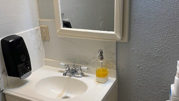 Bañera con ducha, toallas, papel higiénico