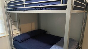 Una cama litera con escalera, ventana y suelo de baldosas.