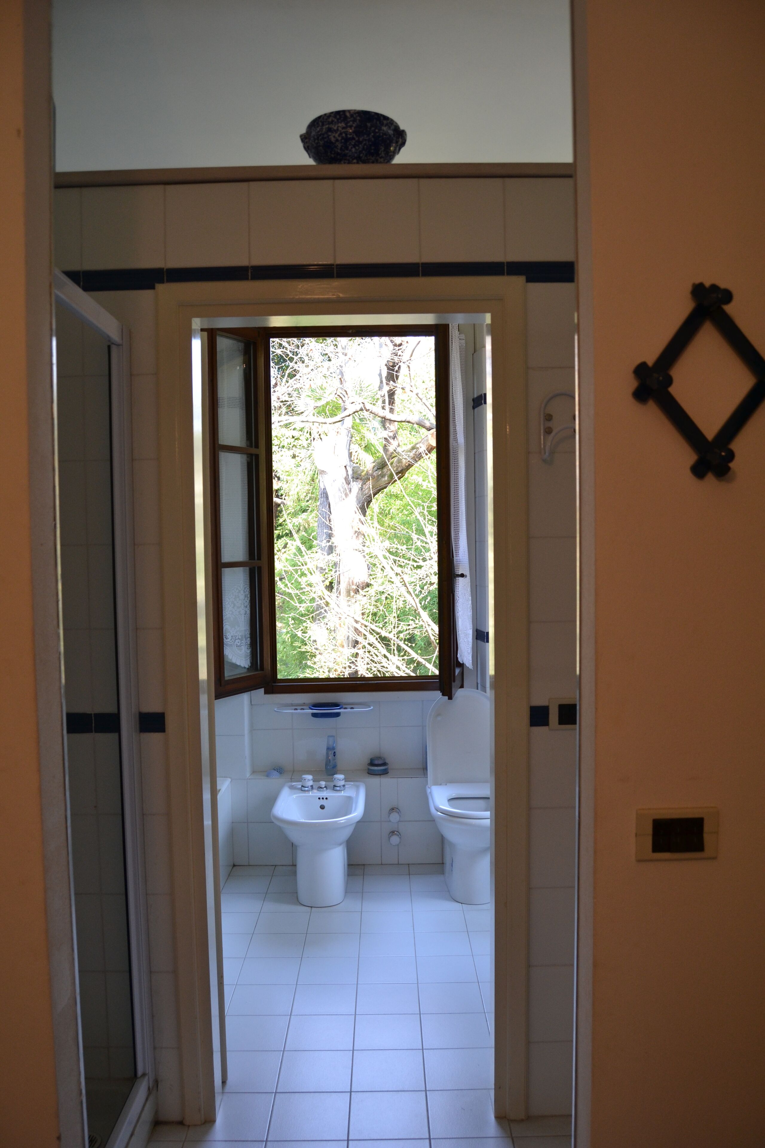 Une salle de bain avec une fenêtre, deux lavabos et des toilettes.