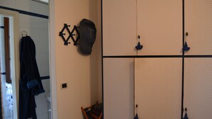 A bathroom with a towel rack, a robe, and a shower caddy. - Elegant private room with lake view balcony (Castelveccana)