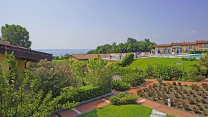 A hotel with a pool, garden, and view of the sea. - Montecolo Resort E7 by Wonderful Italy (Manerba del Garda)