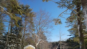 Un petit bâtiment d’un seul étage, doté d’un toit en pente, entouré d’un paysage enneigé et d’arbres.