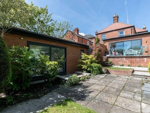 A residential property with a brick house, a glass conservatory, and a garden with stone paving. - Super Chic Apartment in Beautiful Sunninghill - Pass the Keys (Sunninghill)