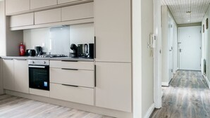 A modern kitchen with beige cabinetry, a built-in oven, and a countertop with appliances. - Historical West Belfast | 5 Mins to City Centre - Pass the Keys (Belfast)