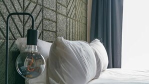 A bed with white bedding and a clear glass bottle with a black cap on a metal stand beside it. - Historical West Belfast | 5 Mins to City Centre - Pass the Keys (Belfast)