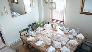 A dining table set for six with white plates, blue rimmed bowls, and gold cutlery. - Eclectic Decor 5 Br house, 2 Baths & 2 Kitchens with WiFi and AC in Old Forge  (Scranton)