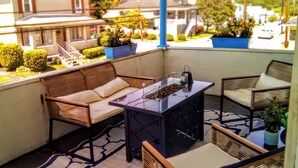 A balcony with wicker furniture, a glass-top table, and potted plants. - Eclectic Decor 5 Br house, 2 Baths & 2 Kitchens with WiFi and AC in Old Forge  (Scranton)