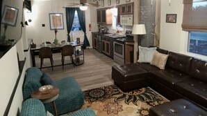 A compact living space with a kitchenette, a dining area, and a seating area with a sofa and ottoman. - Eclectic Decor 5 Br house, 2 Baths & 2 Kitchens with WiFi and AC in Old Forge  (Scranton)
