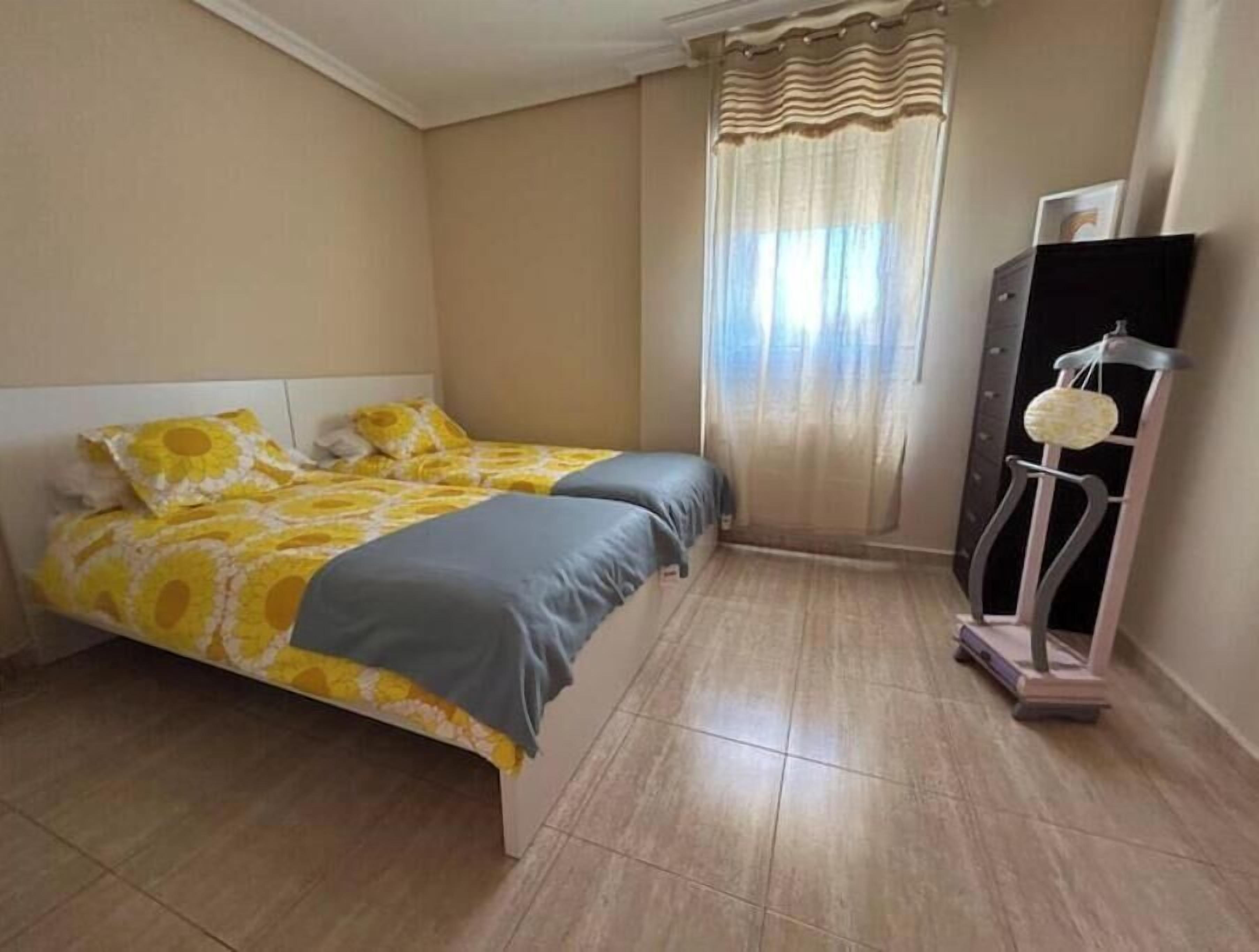 Ein Schlafzimmer mit zwei Betten, einem Kleiderschrank und einem Laufband.