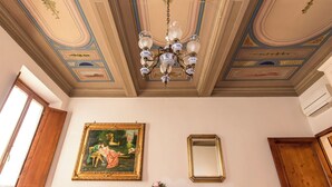 A room with a chandelier, a framed painting, and a mirror. - Antonino 23 - Two Bedroom Apartment, Sleeps 4 (Firenze)