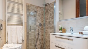 A modern bathroom with a glass-enclosed shower, a white vanity with a mirror, and a toilet. - Antonino 23 - Two Bedroom Apartment, Sleeps 4 (Firenze)