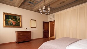 A bedroom with a bed, a dresser, a painting, a mirror, and a door. - Antonino 23 - Two Bedroom Apartment, Sleeps 4 (Firenze)