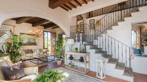 A spacious living area with a staircase, wooden beams, and various plants. - Villa San Miniato Corniano: Iconic 5 Bedrooms Farmhouse with Pool (San Miniato)