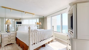 Une chambre spacieuse avec un grand lit, une télévision et une vue sur la mer.