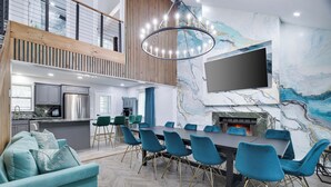 Una sala de estar moderna con comedor, cocina y chimenea.