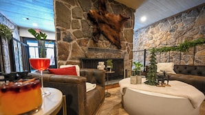 Una sala de estar acogedora con chimenea de piedra, sofás de cuero y una mesa de centro redonda.