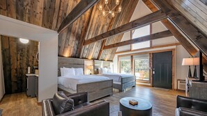 Un dormitorio amplio con una cama grande, una cama más pequeña y una zona de estar con una mesa de café.