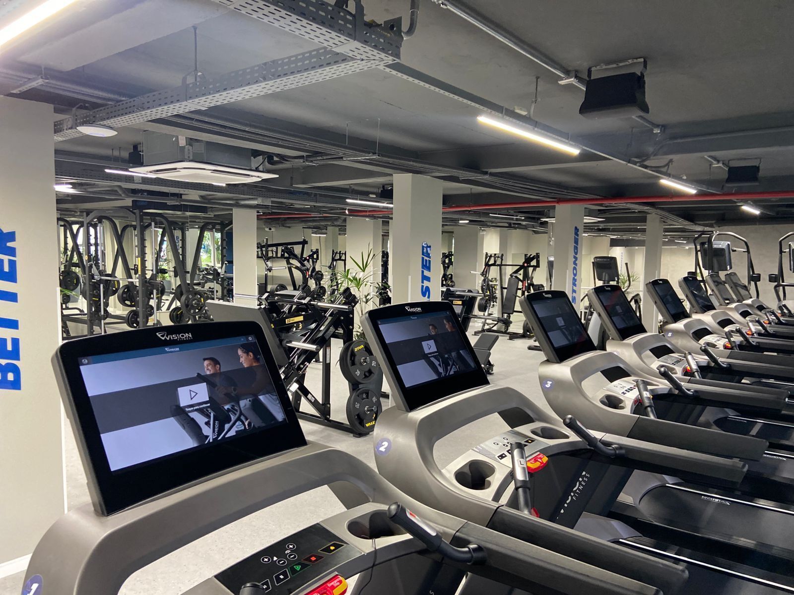 Une salle de sport équipée de tapis de course, d’appareils de musculation et d’autres équipements d’exercice.