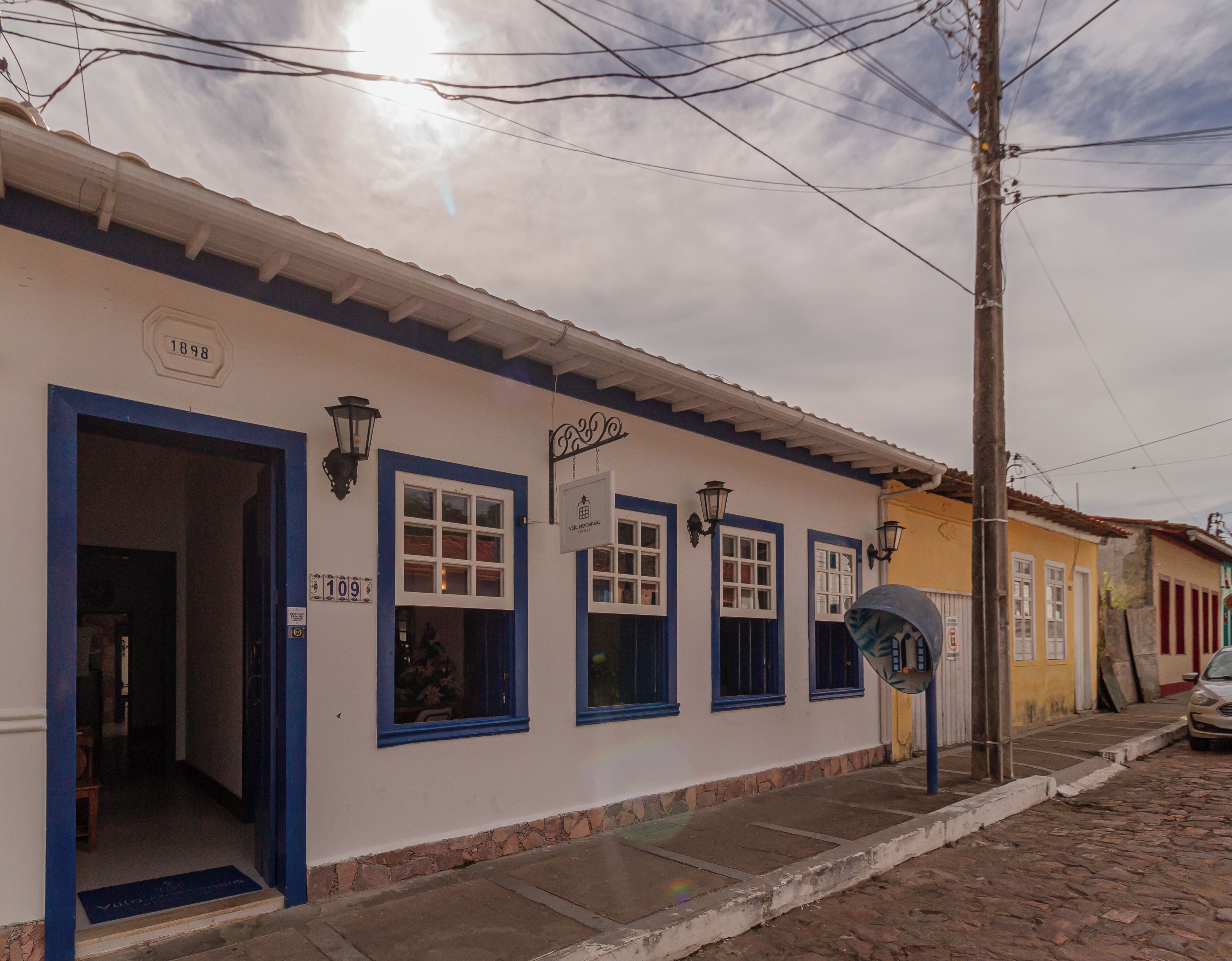 Un edificio con puerta azul, número 109, y un cartel que indica restaurante.