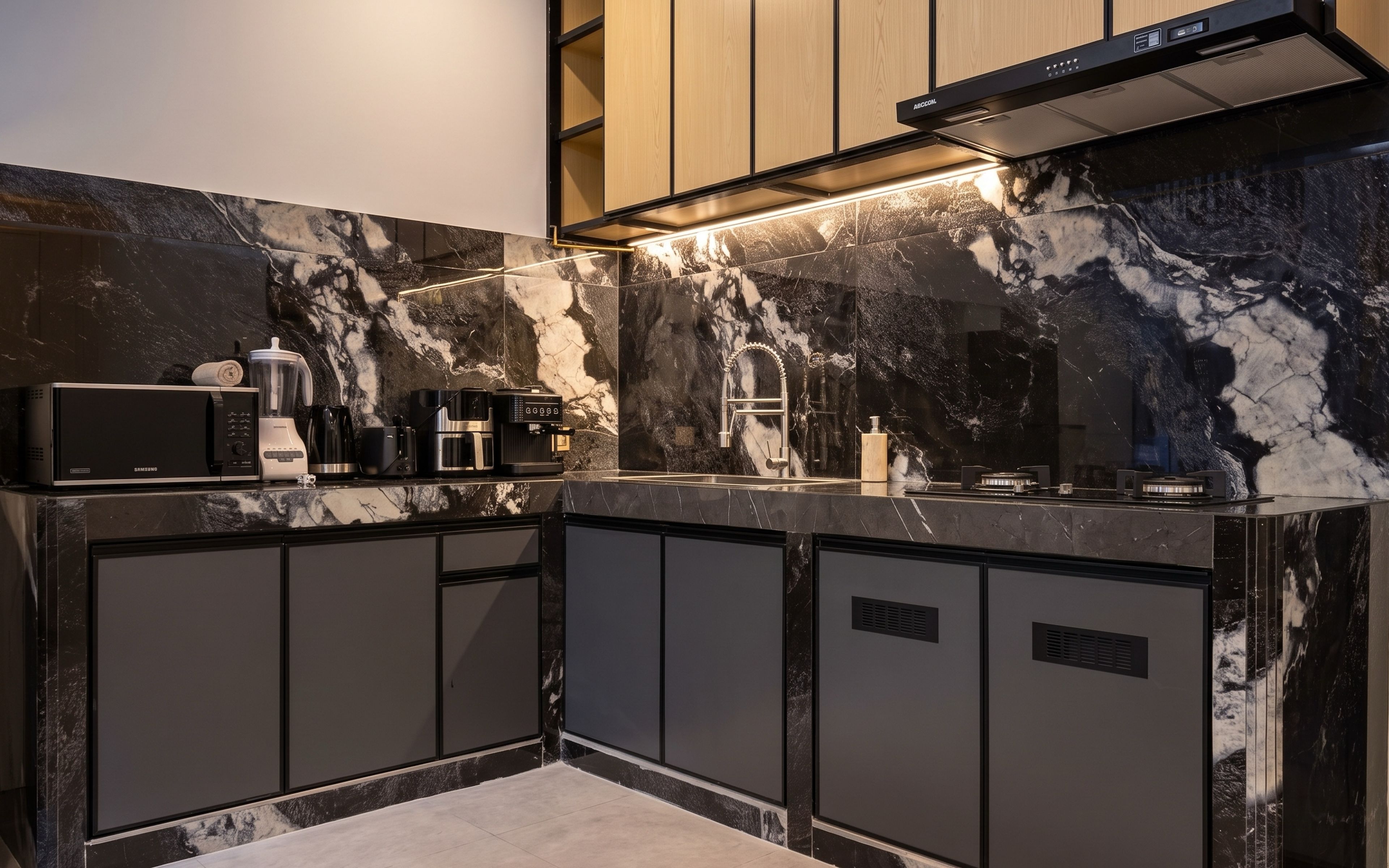 A modern kitchen with a marble backsplash, built-in appliances, and a stainless steel range hood.