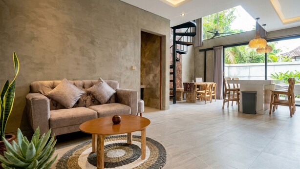 A modern living room with a sofa, coffee table, and plants. - Juminten Villa  (Ubud)