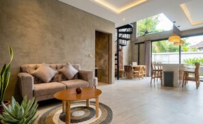 A modern living room with a sofa, coffee table, and plants.