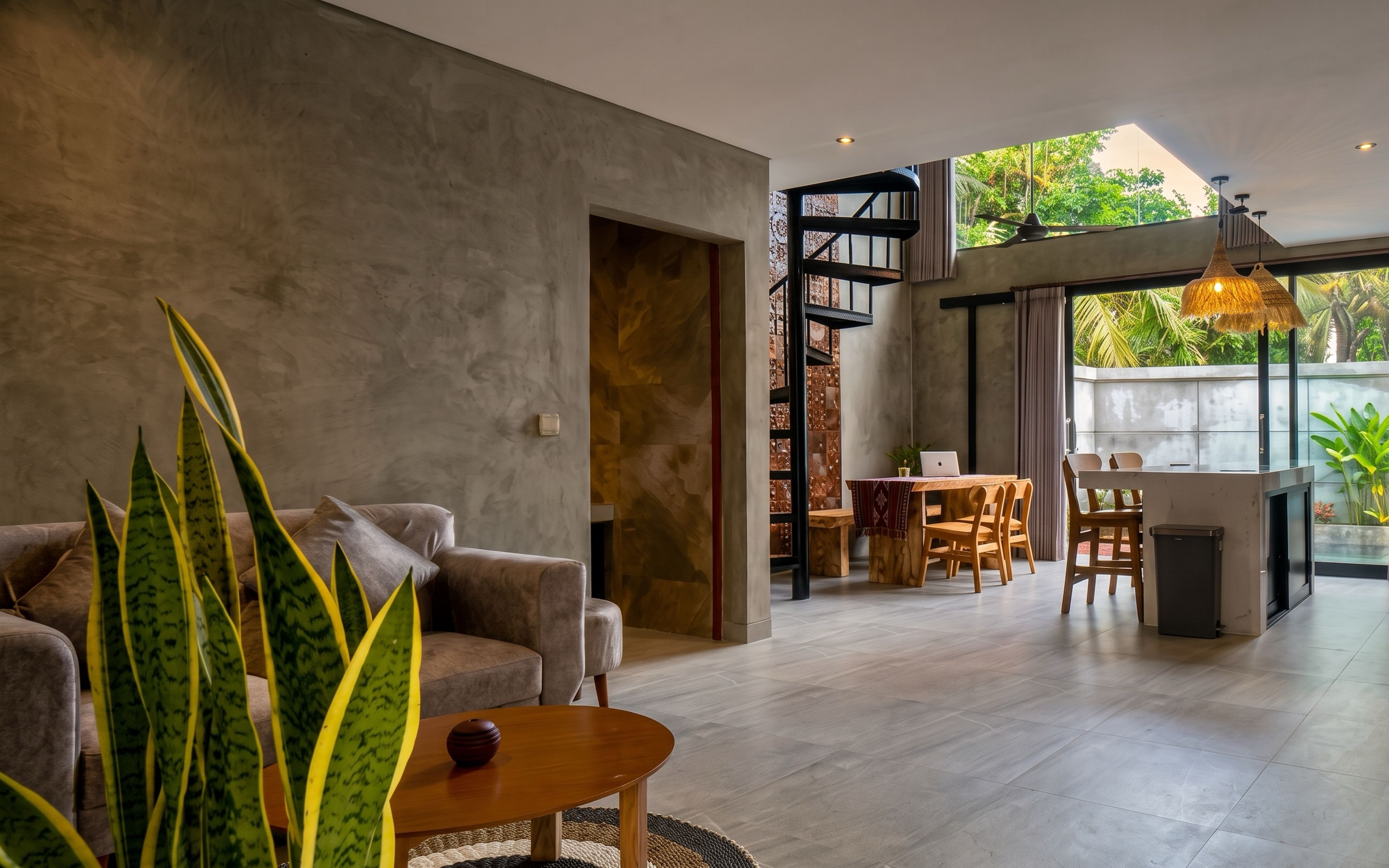 A modern living room with a sofa, coffee table, and a dining area with chairs and a table.