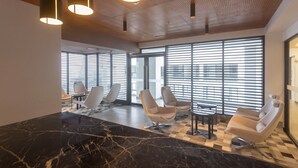 Een moderne lobby met een zwart-wit schachoot patroon, moderne stoelen en hanglampen.